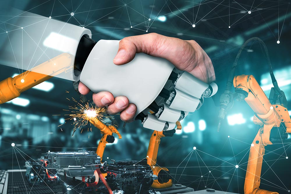Stretta di mano tra una mano umana e una mano robotica in un impianto industriale