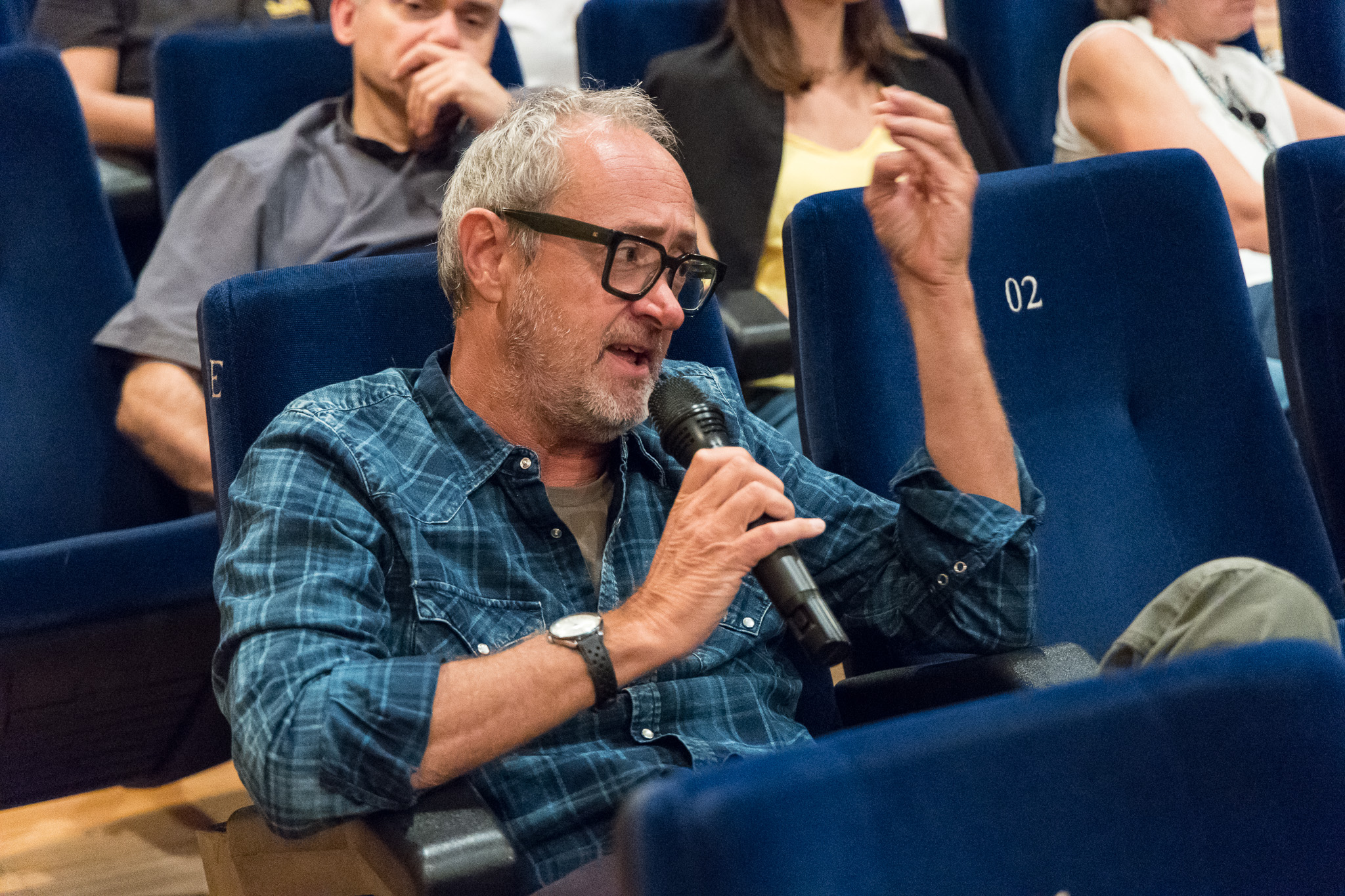 Uomo del pubblico interviene con il microfono dalla platea